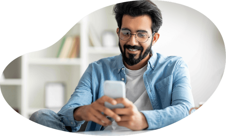 Man in glasses looking at a smartphone smiling