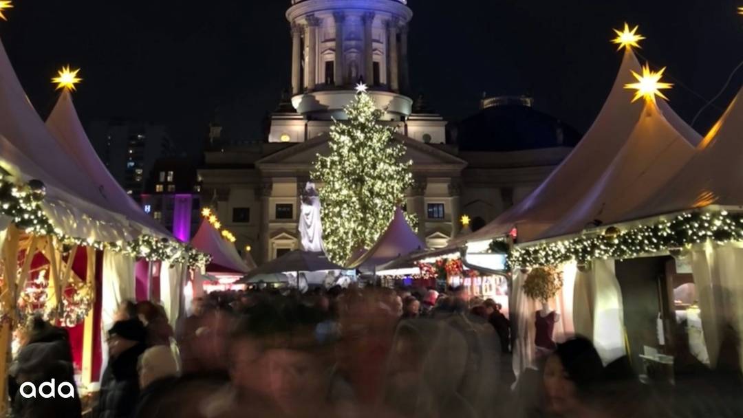The Gendarmenmarkt Christmas market at night with lights and decorations.
